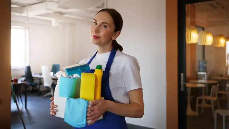 Friendly professional cleaner holding a supply caddy ready for a recurring maid service visit.